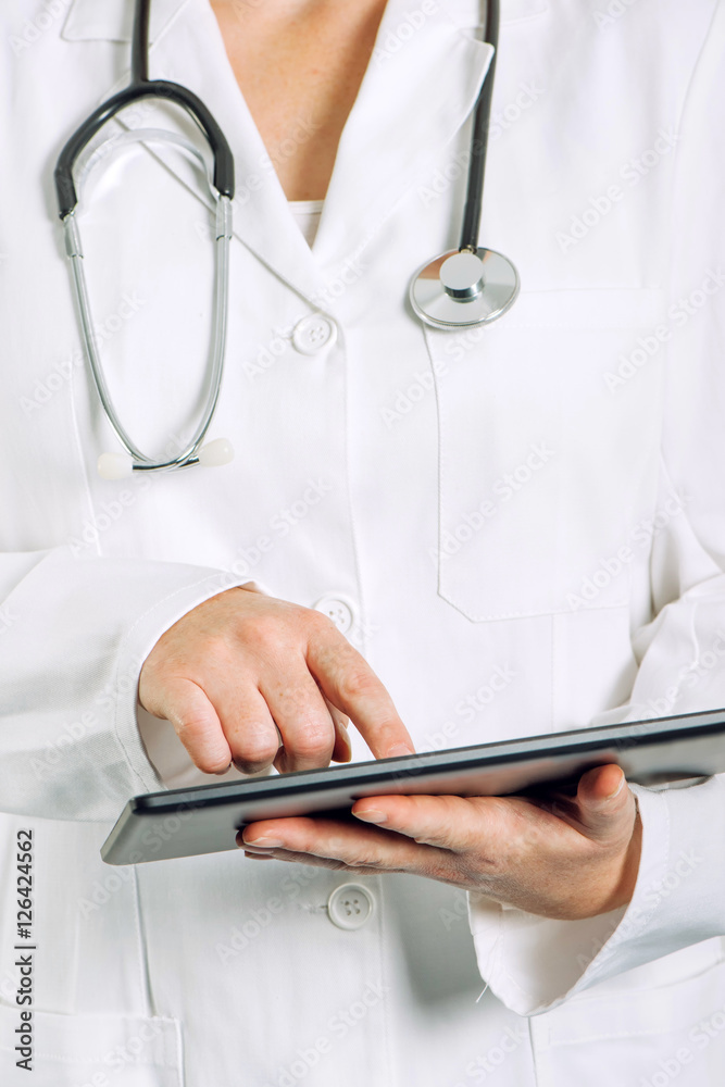 Female general medical practitioner using tablet computer Female general medical practitioner using tablet computer