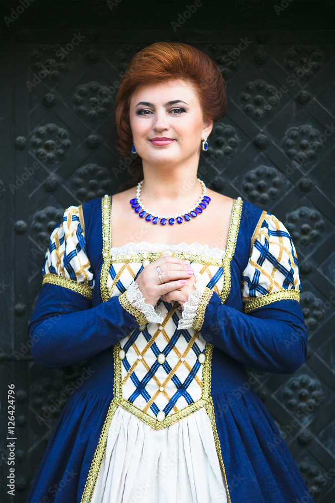Fototapeta premium Beautiful woman in medieval dress in the old town