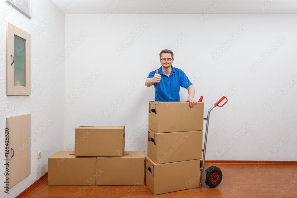 Mann packt Kartons auf eine Sackkarre Mann packt Kartons auf eine Sackkarre