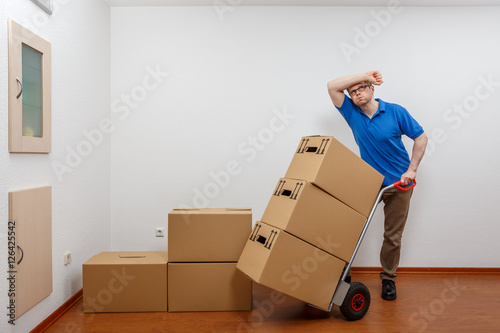 Mann stapelt Kartons aufeinander © levelupart