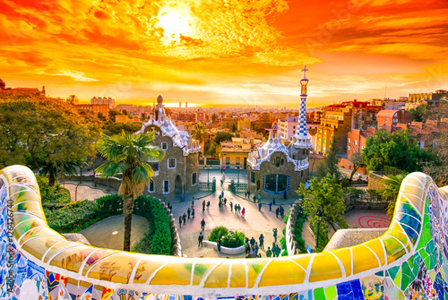 View of the city from Park Guell in Barcelona, Spain, at sunrise with golden sky.