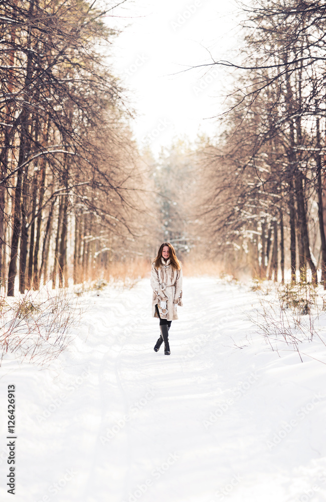 Girl walking in snow. Winter, cold and people concept