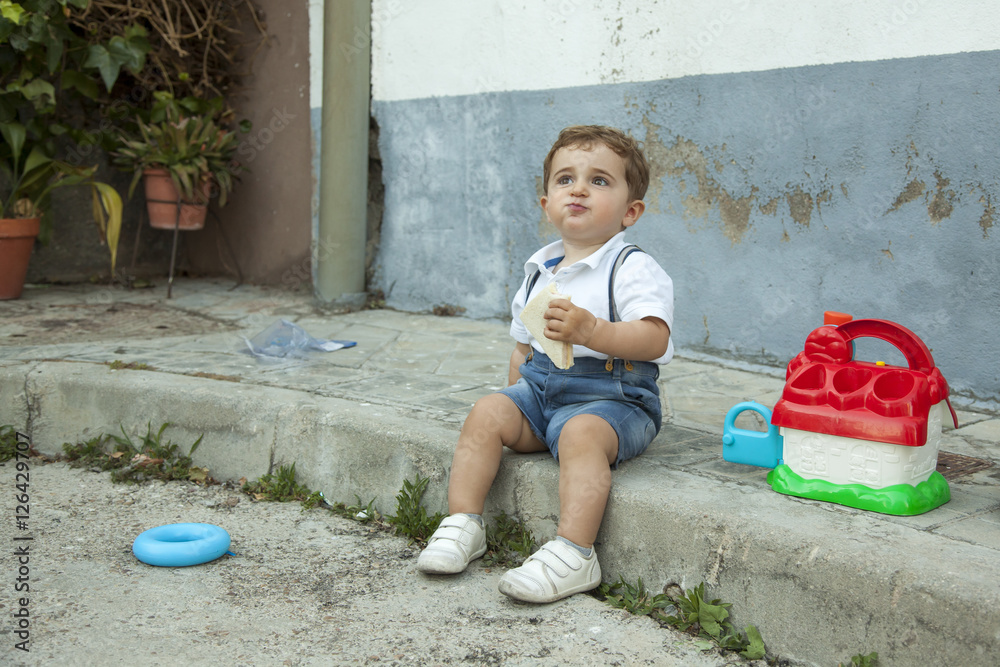 Naklejka premium Full shot portrait cute baby boy having a snack