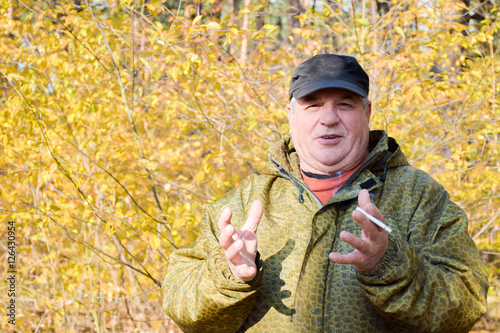 Mature caucasian man smoking cigarette outside