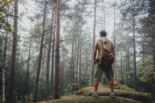 Man using hiking with backpack outdoors in woods