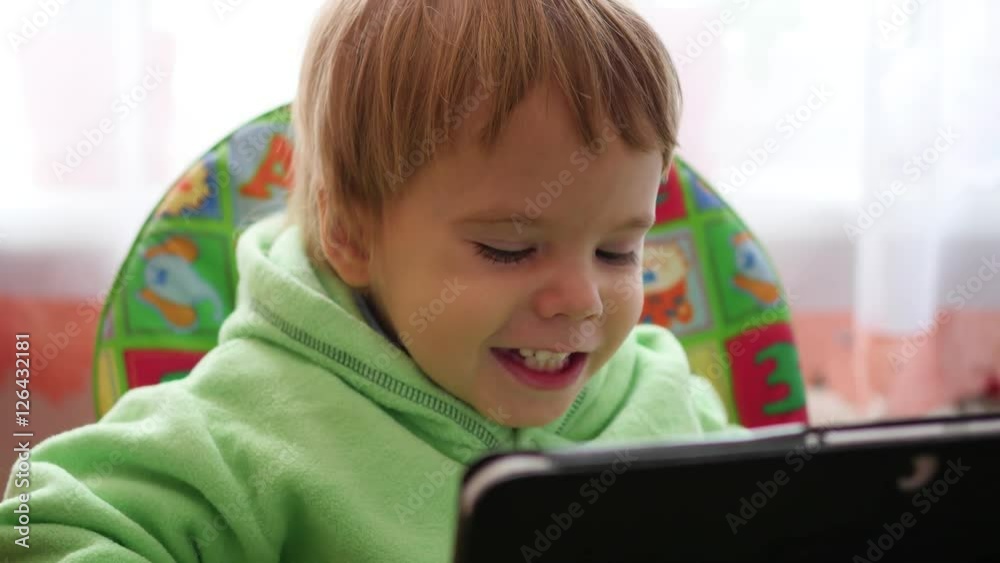 happy child watching cartoons on the tablet and smiling happy child watching cartoons on the tablet and smiling