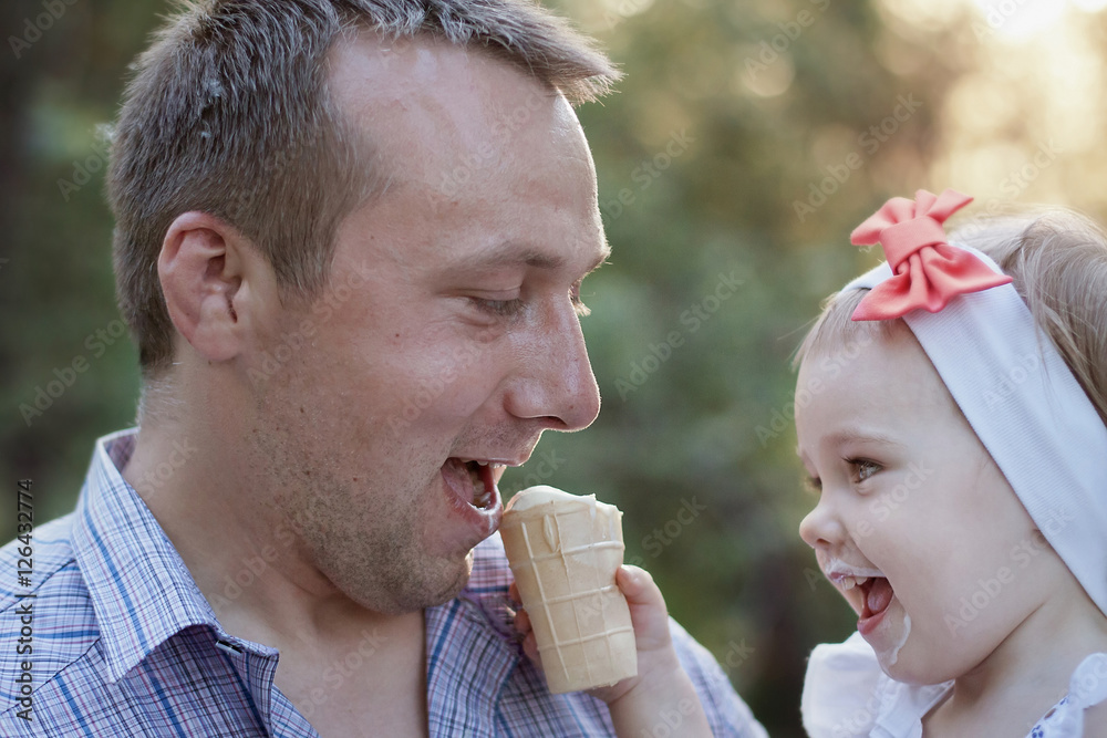 Little cute girl and her father eating ice-cream outside Little cute girl and her father eating ice-cream outside