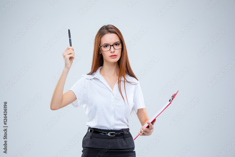 The young business woman with pen and tablet for notes on gray background The young business woman with pen and tablet for notes on gray background