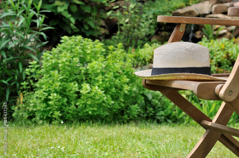 chapeau en paille sur chaise de jardin foto de Stock | Adobe Stock