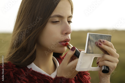 Pretty girl paints lips