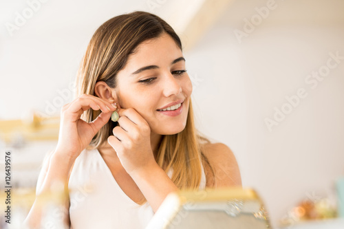 Εκτύπωση καμβά Closeup of a woman trying on some earrings