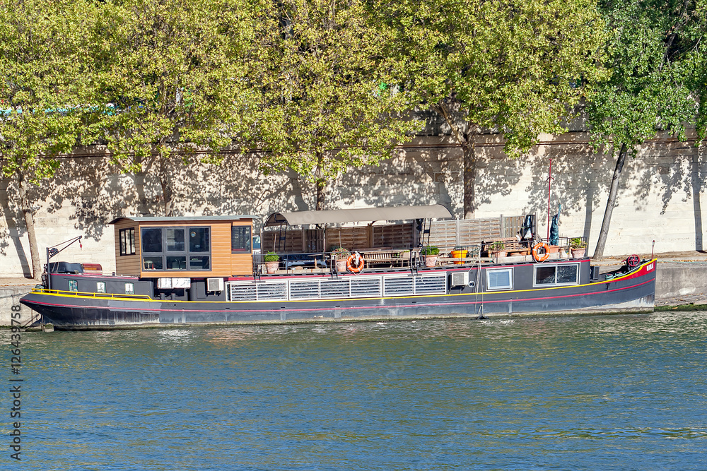 PARIS, FRANCE, April 25, 2016. A Barge on the Seine in Paris. It is very common to see these beautiful boats that serve as housing on the Seine River in Paris