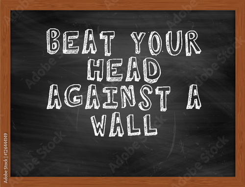 BEAT YOUR HEAD AGAINST A WALL handwritten text on black chalkboa