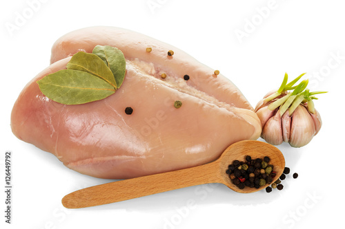 Raw chicken breast, garlic and black pepper in spoon isolated