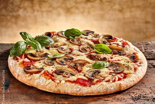 Delicious small pizza with mushrooms and basil