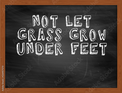 NOT LET GRASS GROW UNDER FEET handwritten text on black chalkboa