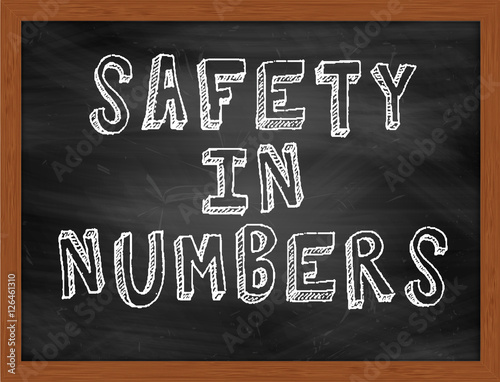 SAFETY IN NUMBERS handwritten text on black chalkboard