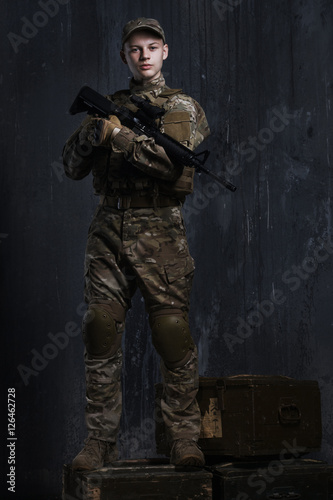 Young men standing on boxes with a rifle. Confident and proud look