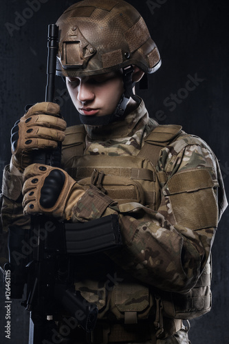 Special forces soldier on dark background. Defeat in a difficult fight