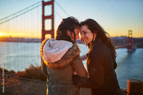 Photography happy romantic female couple at golden gate bridge