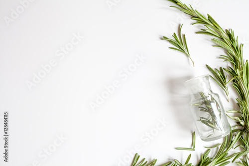 frame from rosemary, bottles on white background top view