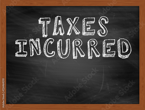 TAXES INCURRED handwritten text on black chalkboard photo