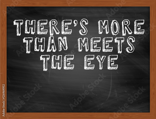 THERES MORE THAN MEETS THE EYE handwritten text on black chalkbo photo