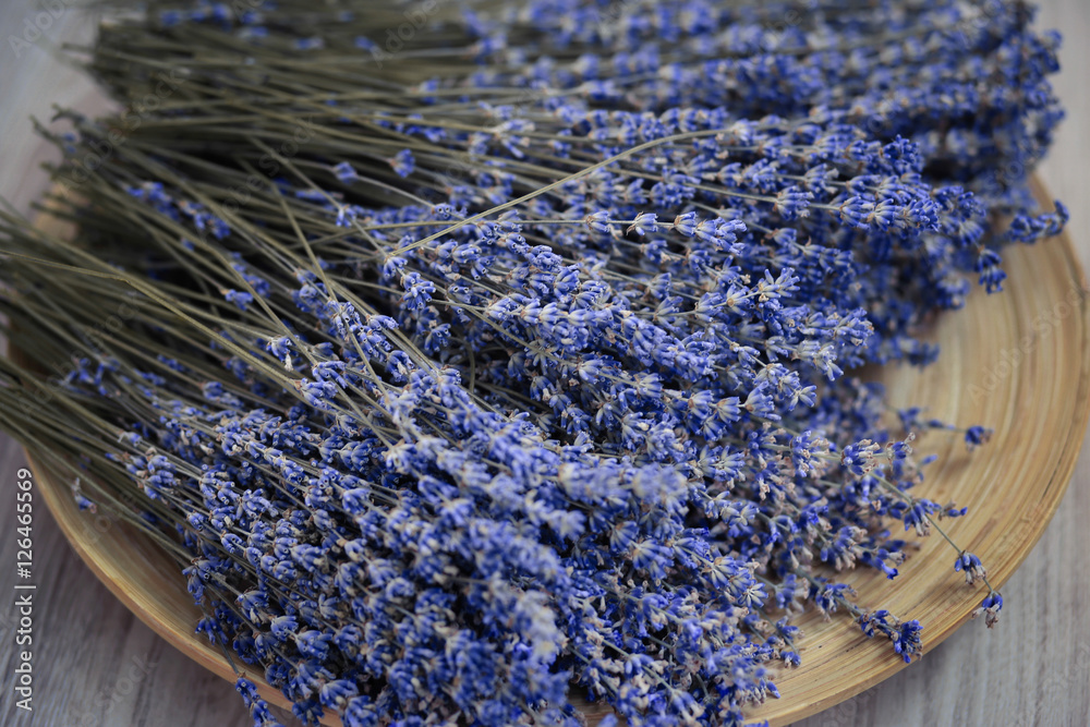 Fototapeta premium Lavender flower branches are on the wooden plate. Beautiful lavender is on the picture 