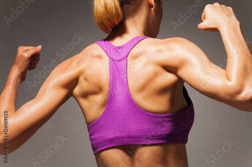 Strong back of fit woman exercising in sport club