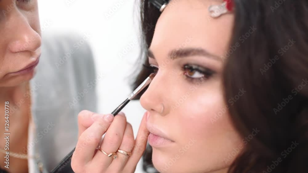 Makeup artist draws arrows, visage master makes eye make up, woman come to beauty salon, woman ask make up artist to do smokey eyes Makeup artist draws arrows, visage master makes eye make up, woman come to beauty salon, woman ask make up artist to do smokey eyes