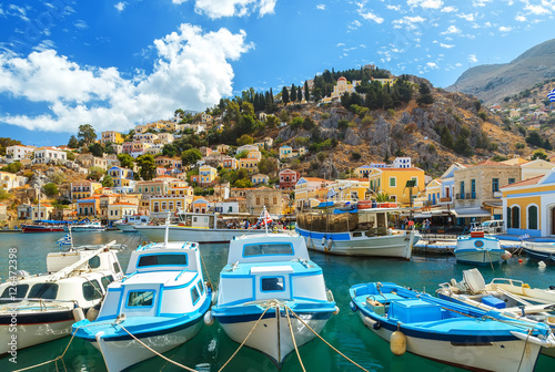Traditional Greek fishing boats in harbour at Symi Town in the Dodecanese Greece Europe