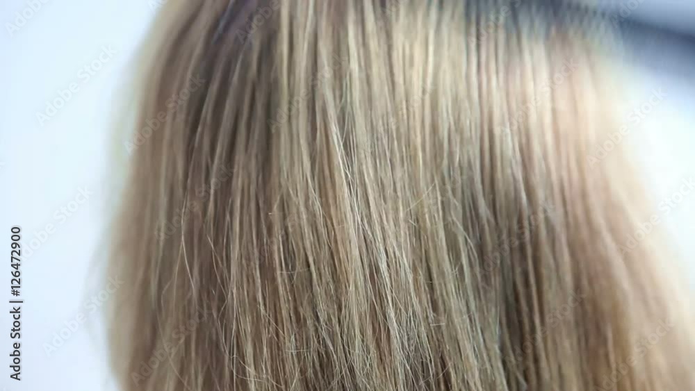 closeup of backside of head with long hair being combed
