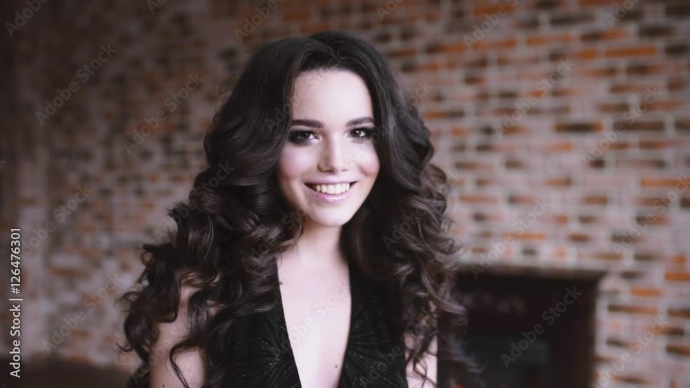 Portrait of sexy caucasian woman with long curl brown hair, girl flirts, woman with beautiful face, girl twists hair on finger Portrait of sexy caucasian woman with long curl brown hair, girl flirts, woman with beautiful face, girl twists hair on finger