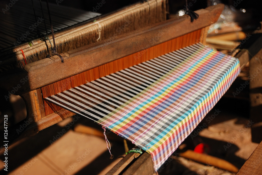 A traditional weaving machine with a colorful velvet