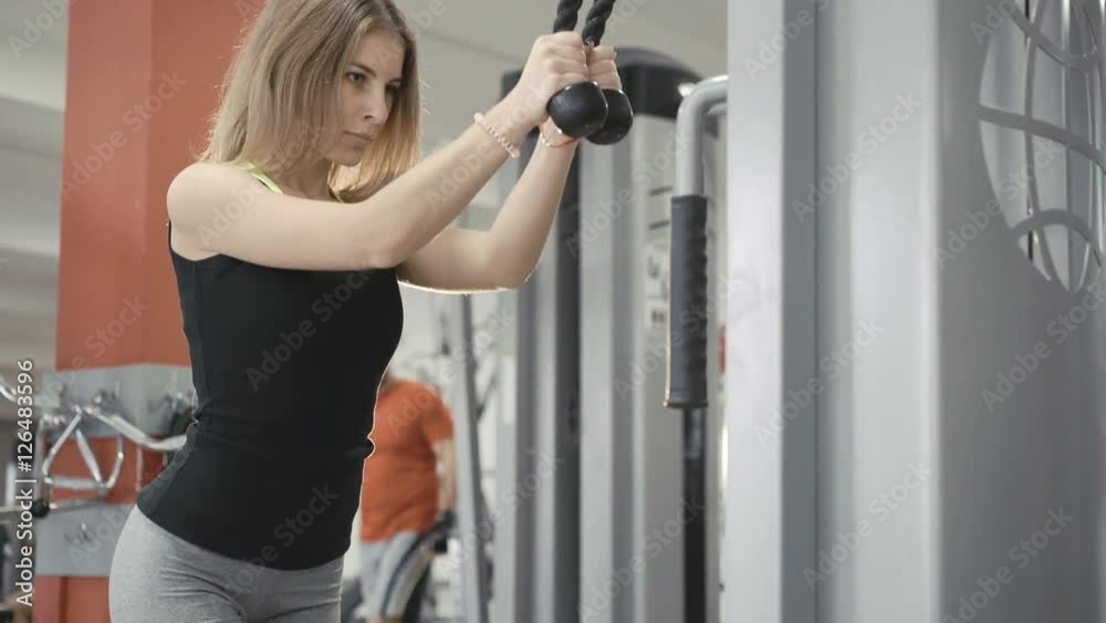 Strong slim girl workout with gym simulator for muscles in the gym in 4K Strong slim girl workout with gym simulator for muscles in the gym in 4K