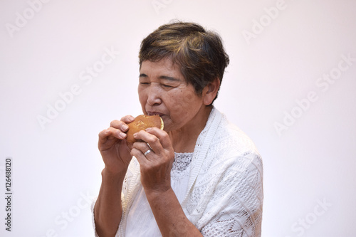 お菓子を食べる60代女性のイメージ