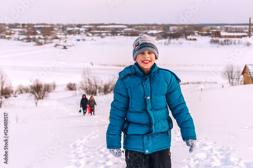 young boy on top of a snowy river Bank