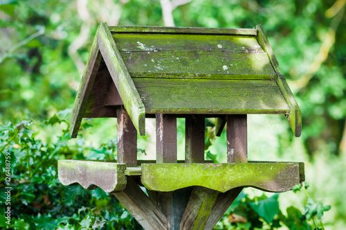 Bird feeder house shaped garden accessory weathered covered in moss