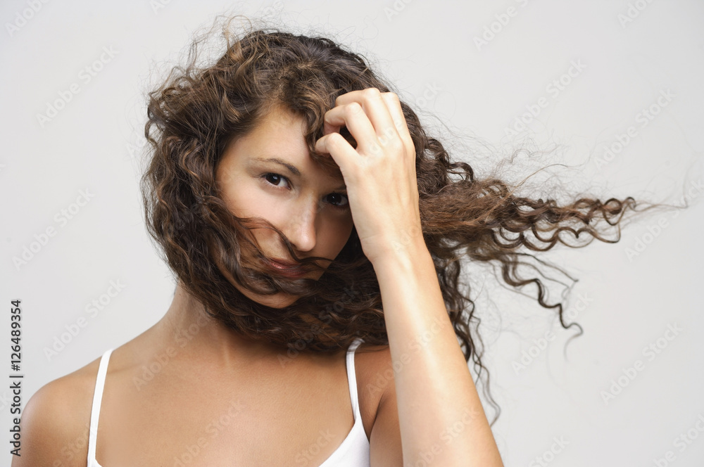 Woman with windswept hair, hand on head Woman with windswept hair, hand on head