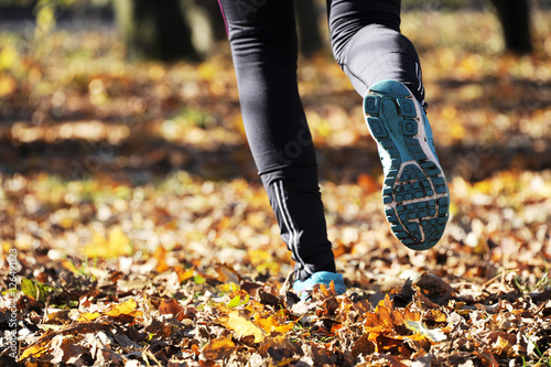 Young woman running outdoors in a autumn forest on a cold fall/winter day, lifestyle and healthy concept