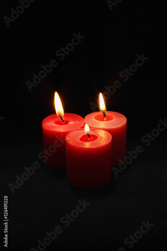 Three lit red candles