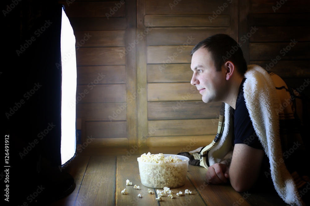 Fototapeta premium young man watching television at home on the floor