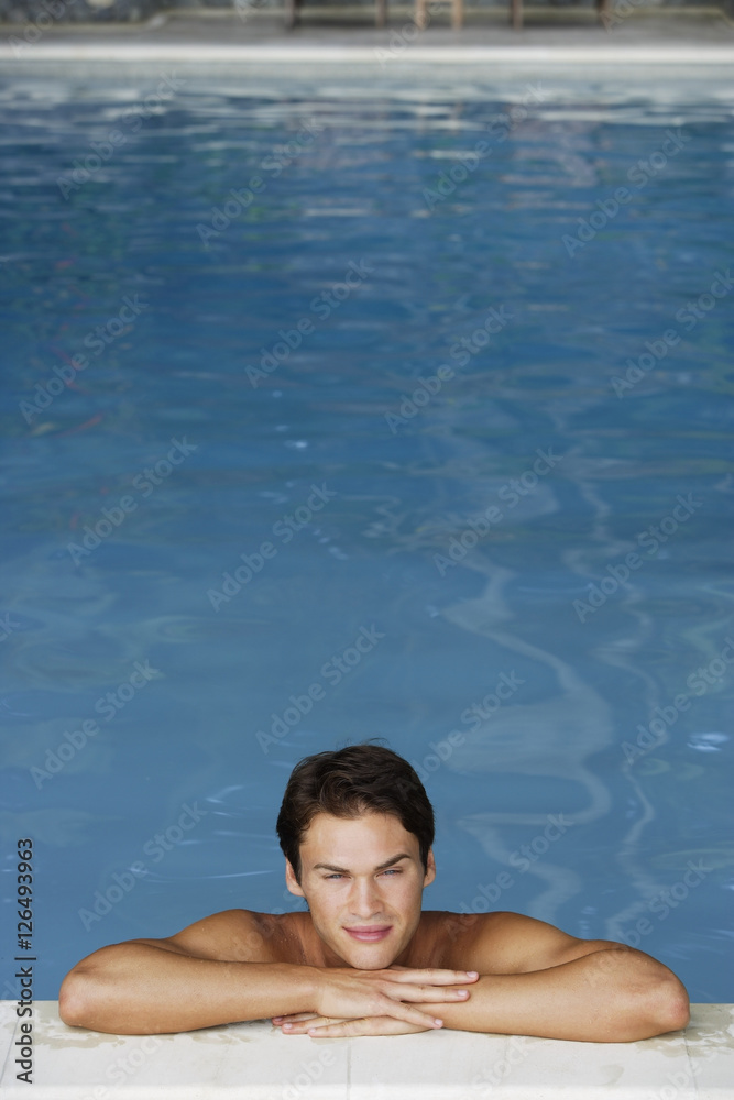 young man leaning on edge of pool