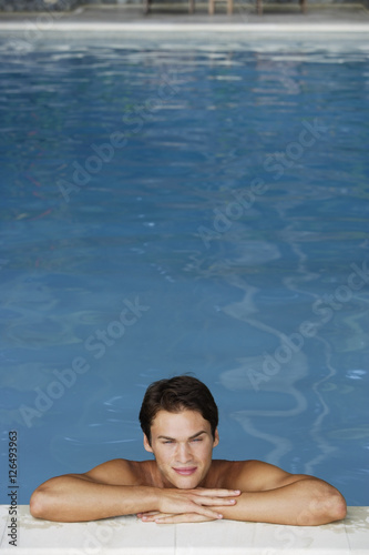 young man leaning on edge of pool