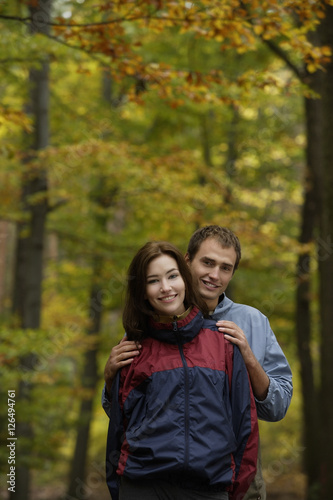 Young couple in hiking clothes standing in forest © Alexander