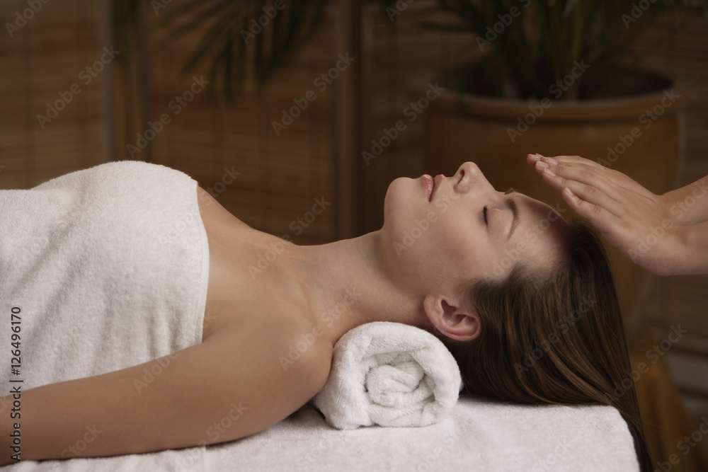 Young woman receiving reiki massage