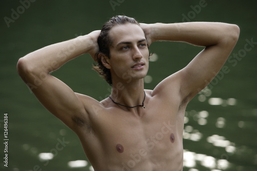Obraz na płótnie Young man standing in lake, hands on head w salonie
