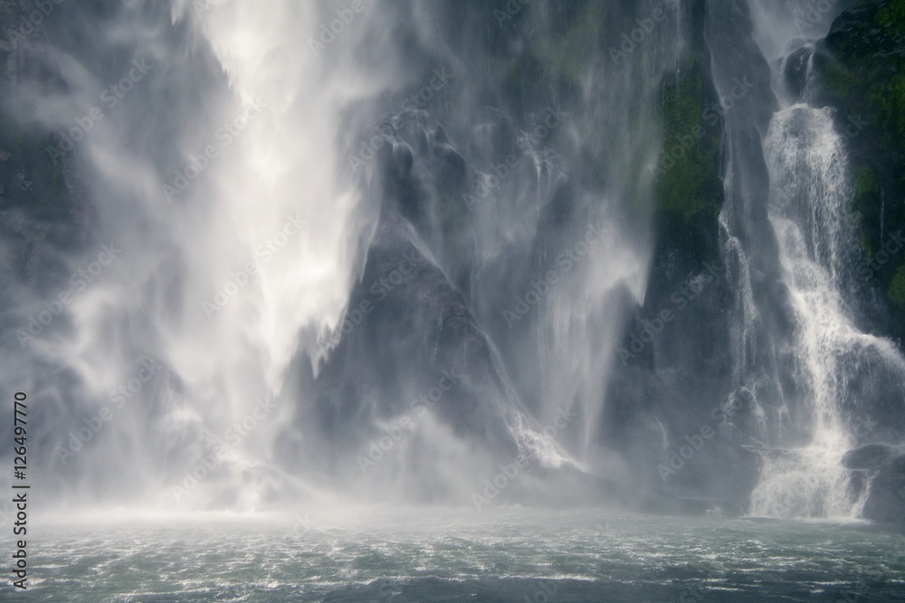 Milford Sound waterfall creates amazing patterns as it hits the Sound's surface, New Zealand.