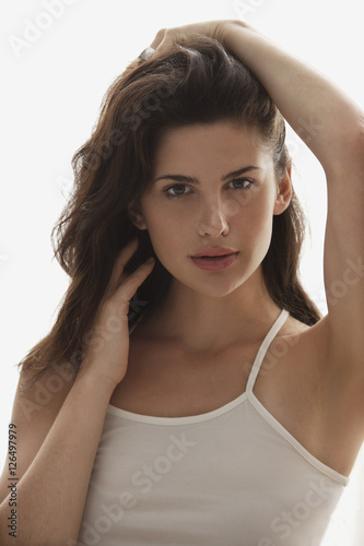 portrait of young woman, holding hair on top of head