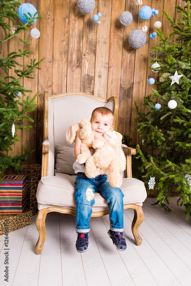 Little boy playing with toy at home near the Christmas tree. Little boy playing with toy at home near the Christmas tree.